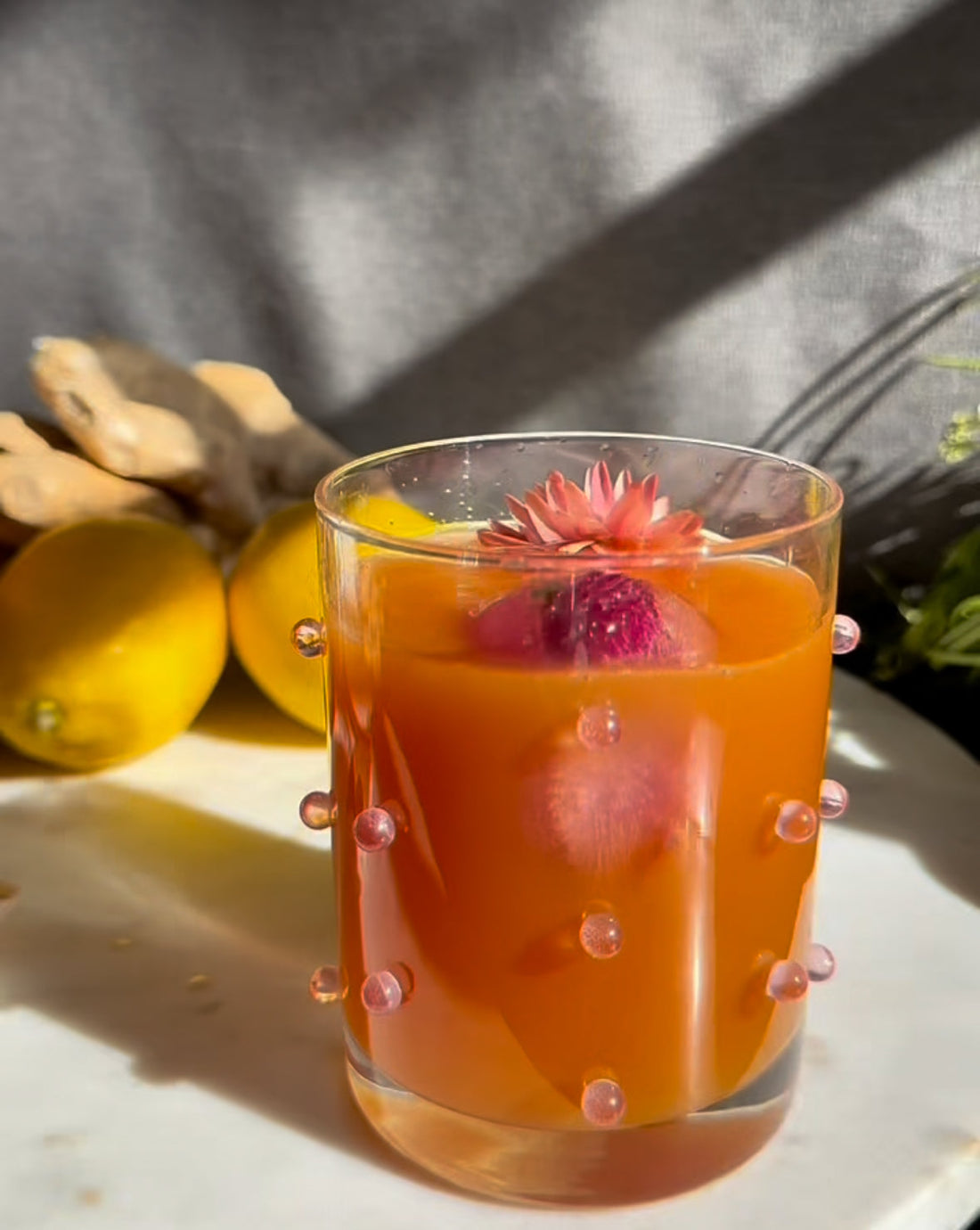 orange cocktail with edible flower garnish